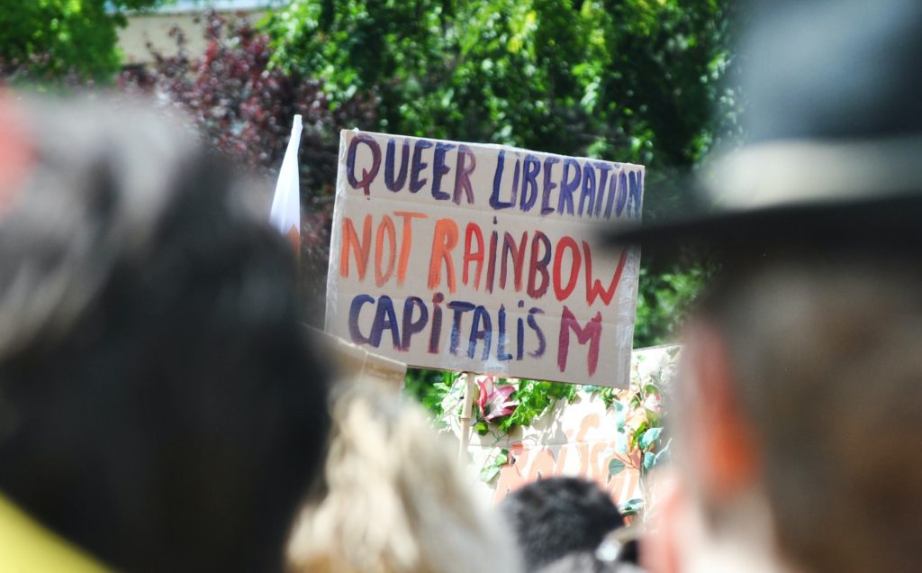A placard that says "Queer liberation not rainbow capitalism"
